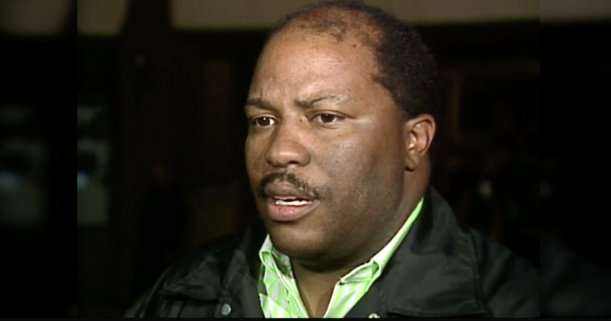 A man stands at a crime scene talking with reporters in 1991.