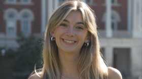 A photo of reporter Rylie McNanna wearing jeans and a pale yellow tank top. She is standing on the Francis Quadrangle, and Jesse Hall is behind her.