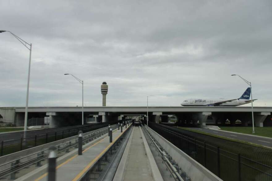 A Jetblue plane taxis over the APM track to the South Terminal. Photo: Matthew Peddie, WMFE