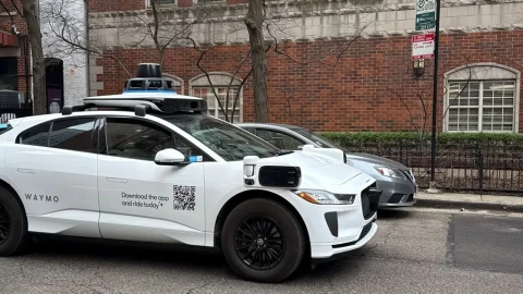 A Google-operated Waymo vehicle drives through Chicago’s Near North Side, with a driver, as the company begins testing and mapping the city in March 2026.
