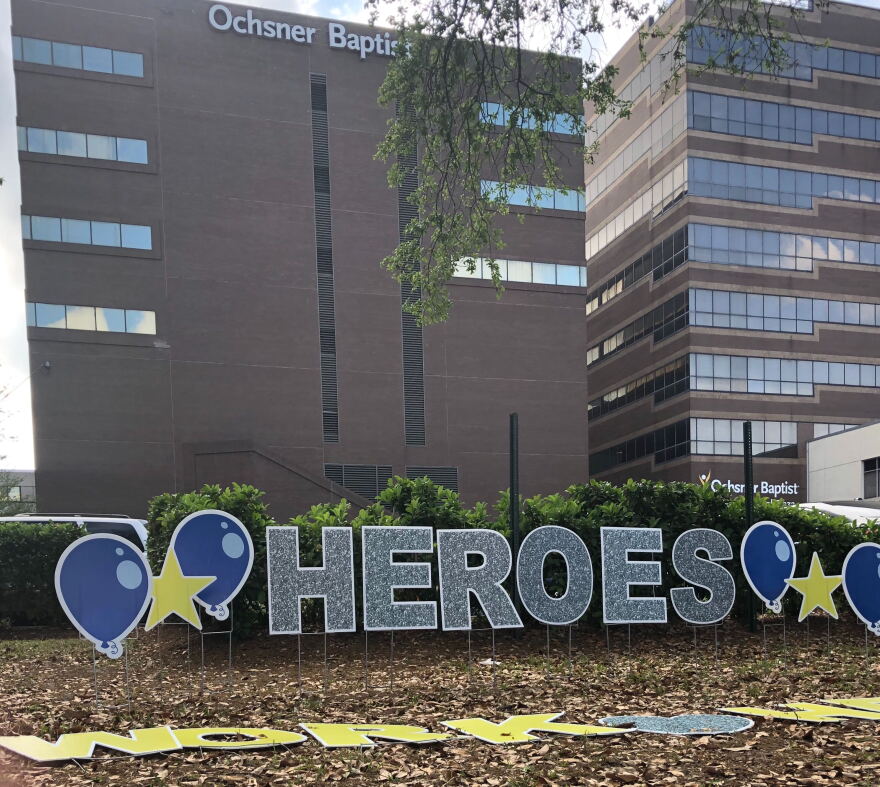 Outside Oshner Baptist hospital in New Orleans, a volunteer puts up decorations celebrating healthcare workers helping combat the coronavirus.
