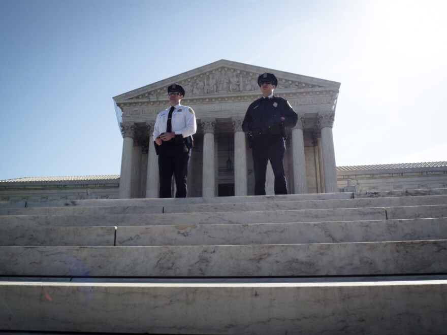 Two policemen guard outside the US Supreme Court on the third day of oral arguements over the constitutionality of the Patient Protection and Affordable Care Act on March 28, 2012 in Washington, DC. The 26 states challenging the law argue that the Act must be completely repealed.