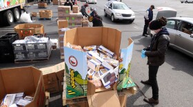 A volunteer prepares to load food into a car at a mobile pantry April 14, 2020 in Detroit, Michigan. The organization distributes food throughout the metro area, which has seen an uptick in demand due to the COVID-19 pandemic. (Gregory Shamus/Getty Images)