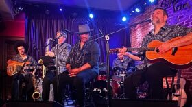 Vocalist Gina Coleman sits on stage surrounded by the musicians from the group Misty Blues.