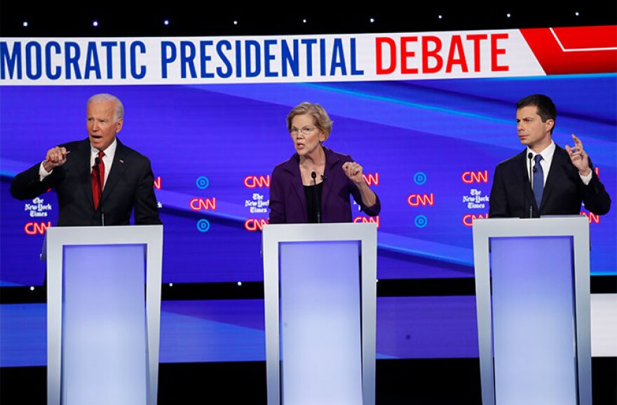 Democratic presidential candidate former Vice President Joe Biden, left, Sen. Elizabeth Warren, D-Mass., center and South Bend Mayor Pete Buttigieg speak during a Democratic presidential primary debate hosted by CNN/New York Times at Otterbein University.