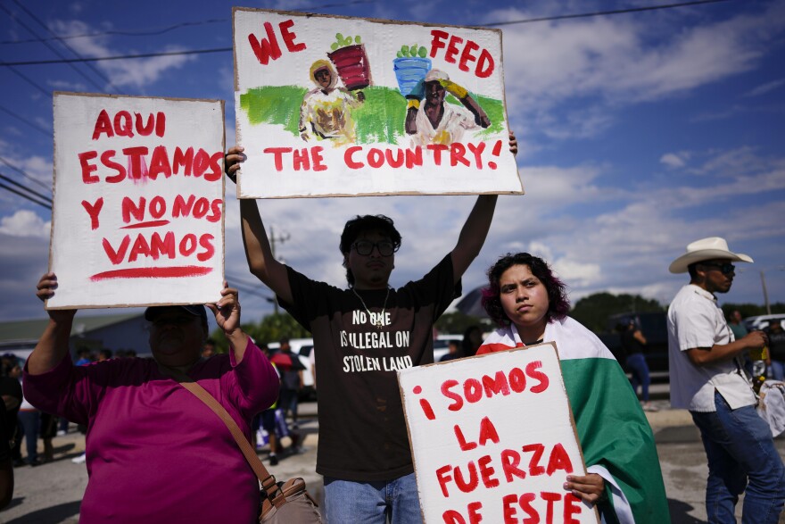 Artist Jonathan Martinez, 22, center, whose Mexican parents first worked on farms when they arrived in the U.S. more than two decades ago, holds a hand-painted sign as protests along with his sister Paola, right, a 19-year-old cosmetology student, against Florida Senate bill 1718, which imposes restrictions on undocumented immigrants, Thursday, June 1, 2023, in Immokalee, Fla.