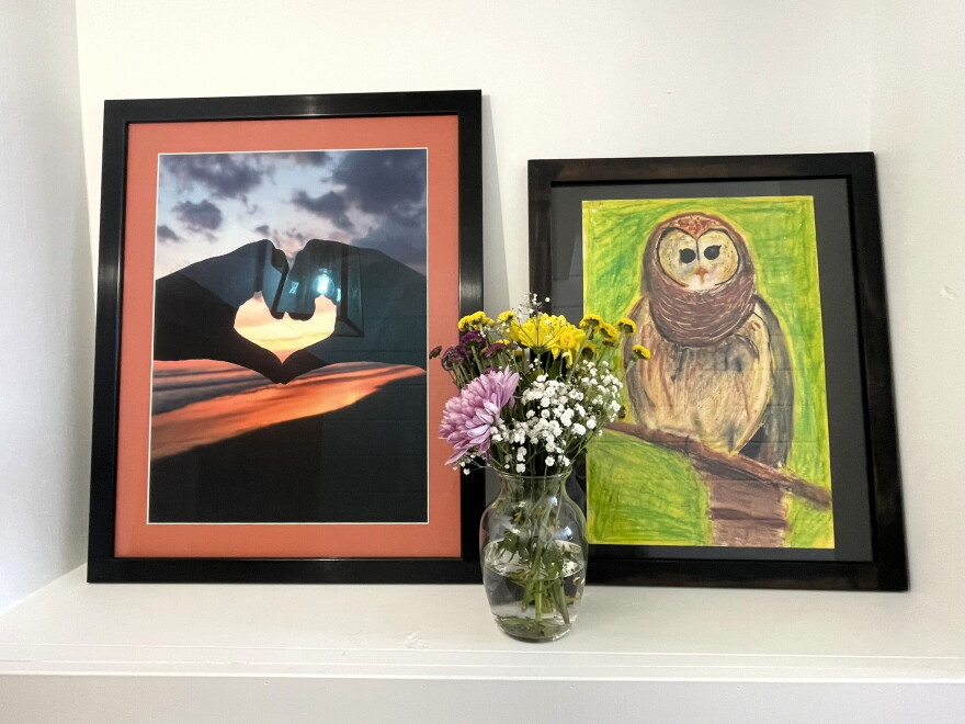 A photograph of sisters Alyssa and Emily Peterson forming a heart with their hands, left, sits beside Alyssa's owl artwork at the family’s home in Arvada on Sept. 22, 2026.