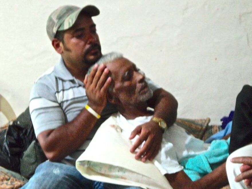 Marlon holds his father. Guillermo, as the family gathers.