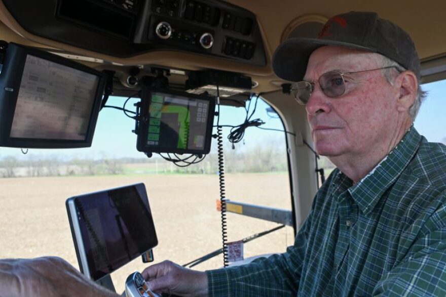 Frank Glenn operating a tractor. Three screens are on the inside of the tractor.