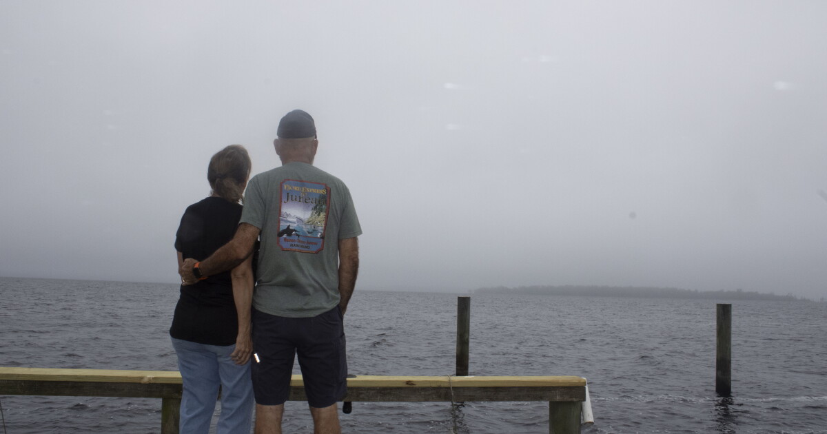 Janet and Steven Simoneaux on a dock looking over Crescent Lake on a foggy morning