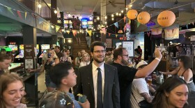 William Lawrence looking up ahead in a crowded bar