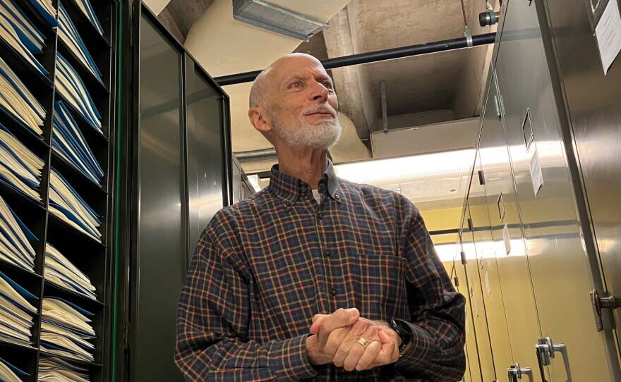 Jonathan Wendel, distinguished professor in the Department of Ecology, Evolution and Organismal Biology at Iowa State University, stands next to a shelf containing pressed and dried plant samples in the Ada Hayden Herbarium at Iowa State University.