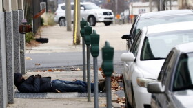 A man who is homeless takes advantage of the warm air coming from a sidewalk vent to stay warm in downtown Jackson, Miss., Wednesday, Dec. 27, 2017. (Rogelio V. Solis/AP)