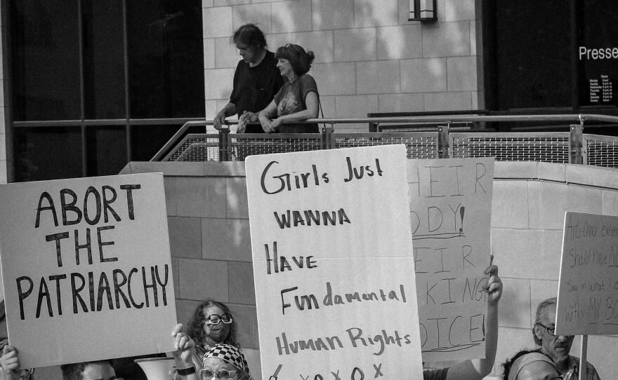 Demonstrators hold up signs as they march toward downtown Columbia to protest the overturn of Roe vs Wade.