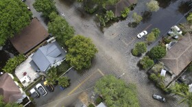 A pair of waterlogged cars sit abandoned in the road as floodwaters recede in the Sailboat Bend neighborhood of Fort Lauderdale, Fla., April 13, 2023. Flood risk and climate change are pushing millions of people to move from their homes, according to a new study by the risk analysis firm First Street Foundation.