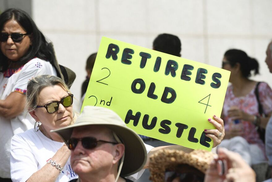 Yvonne Landin, a retired teacher from Corpus Christi, holds a sign as retired teachers gather at the Teacher Retirement building in Austin on Thursday.