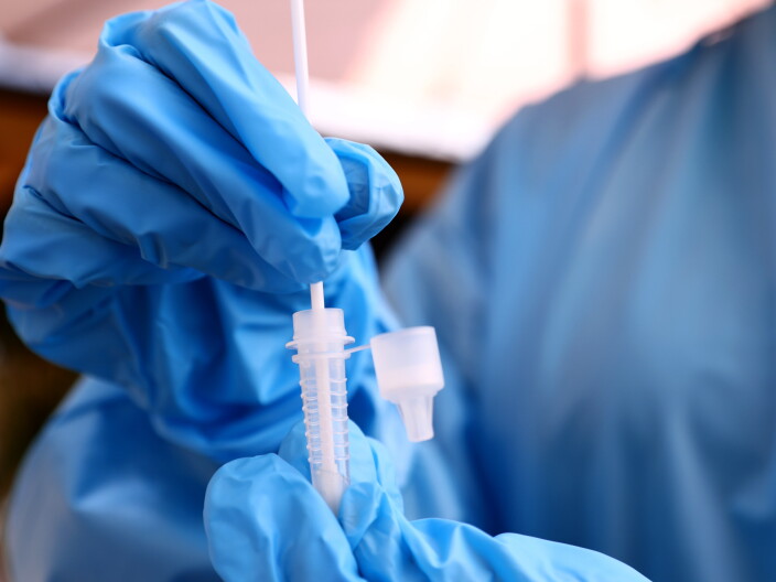 A registered nurse stirs a nasal swab in testing solution after administering a COVID-19 test in Los Angeles, Calif. Increased testing could help in efforts to detect and track new variants like omicron.