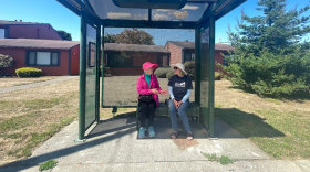 Two Humboldt County residents wait for public transit at a local bus stop.