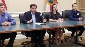 Gov. Ron Desantis at a table with members of his staff.