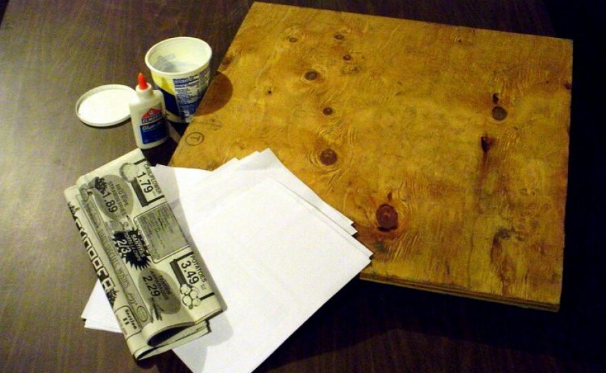 Materials - 2’ X 2’ X 1” piece of plywood, computer paper, newspaper, school glue, and a plastic container. 