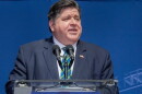 A man in a suit speaks at a podium