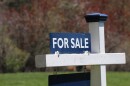 A for sale sign on a white post