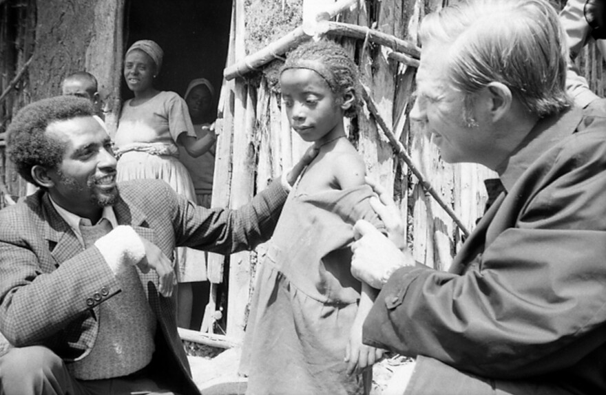 Dr. Donald A. Henderson (right), who led the World Health Organization effort to eradicate smallpox, examines a child's vaccination scar in Ethiopia.