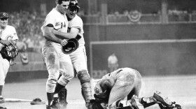 Pete Rose, left, is hugged by teammate Dick Dietz while catcher Ray Fosse kneels injured on the ground. Rose crashed into Fosse to score the winning run for the National League team in the 12th inning of the 1970 All-Star Game in Cincinnati. 