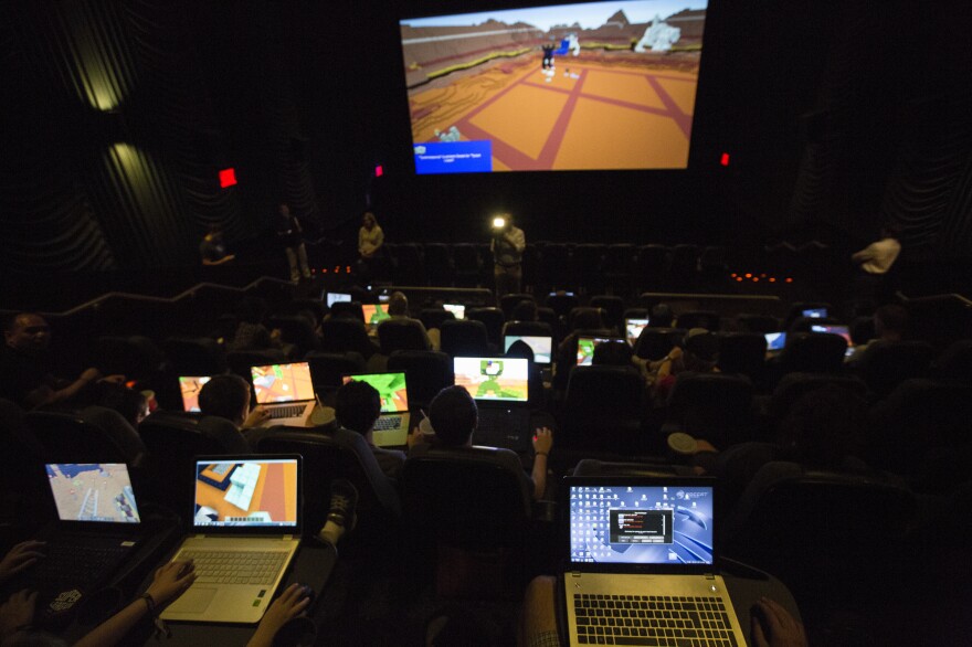 Gamers connect their laptops to the large movie theater screen to play Minecraft together for the Super League Gaming event.