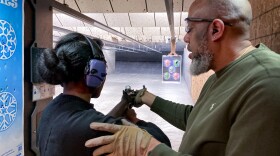 Sharis Lewis of Florissant, Missouri, tries a 12-gauge shotgun with the help of her husband, Russell, at the SharpShooter, an indoor range near south St. Louis.