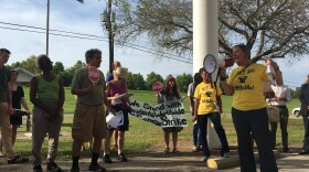 Anne Rolfes, with the Louisiana Bucket Brigade, leads a crowd in a protest chant prior to a public meeting in Vacherie, LA related to the proposed Formosa chemical plant. Residents in the region have been protesting against industry for years. 