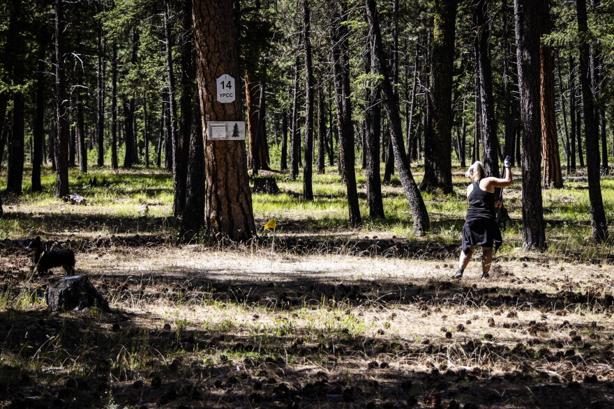 Ronda Rogers rakes the 14th green at Yellow Pine’s quaint golf course.