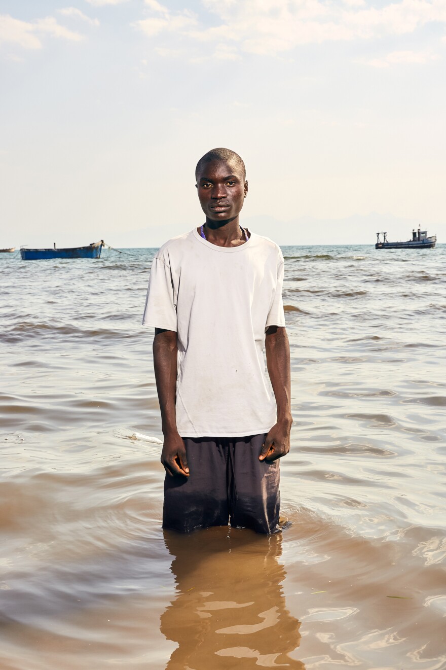 Fisherman Mekius Dominic stands in Lake Malawi. Dominic became a fisherman three years ago. He says he has never engaged in transactional sex but knows plenty of men who do. "My friends have said to me that I must do it. They force me to come with them and drink beer. Then they tell me I have to have sex with a woman there. But I do not do it."