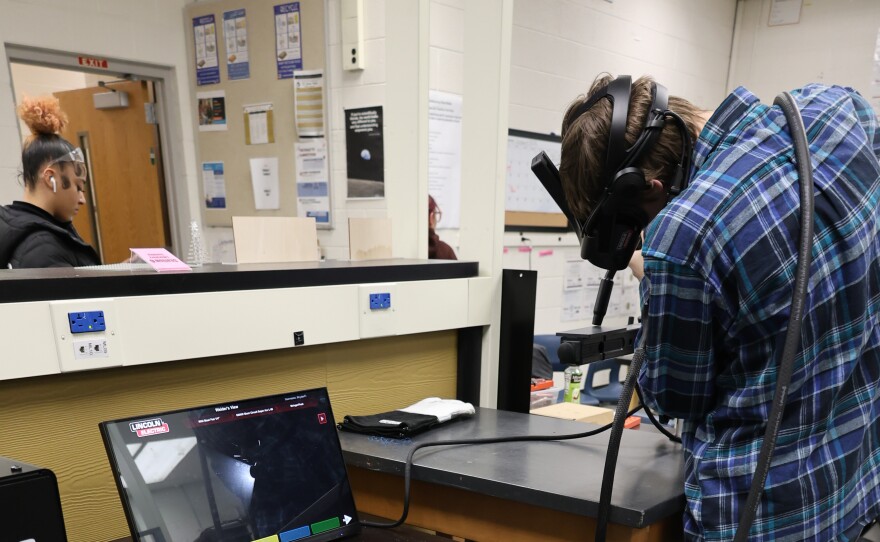 An Ypsilanti Community High School students installs podcasting equipment.