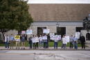 Scott County Democrats hold signs. (Chris Bentley/Here & Now)