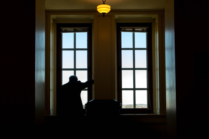 Randy Scherr, a lobbyist for Scherr Winter LLC, leans into a window sill while talking on the phone on Wednesday during the first day of the legislative session at the capitol in Jefferson City.