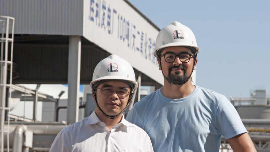 Akshat Rathi (R) on a tour of Sinopec's Shengli Dongying coal power plant. In the background, the plant's carbon capture unit.