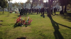 County employees, media and mourners gather for the ceremony honoring the 1,489 people whose unclaimed remains are being buried in the LA County Cemetery this year.
