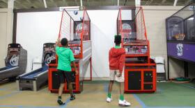 Kids play a basketball arcade game during camp at a recreation center in Baton Rouge on June 2, 2026.