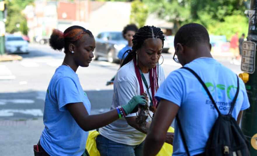 Tisha Barber, center, and her students from the Harrisburg Housing Authority’s Environmental Teen Corporation pick up trash along Market Street in Harrisburg on August 2, 2022.