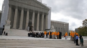 People line up to enter the Supreme Court on Monday for arguments.
