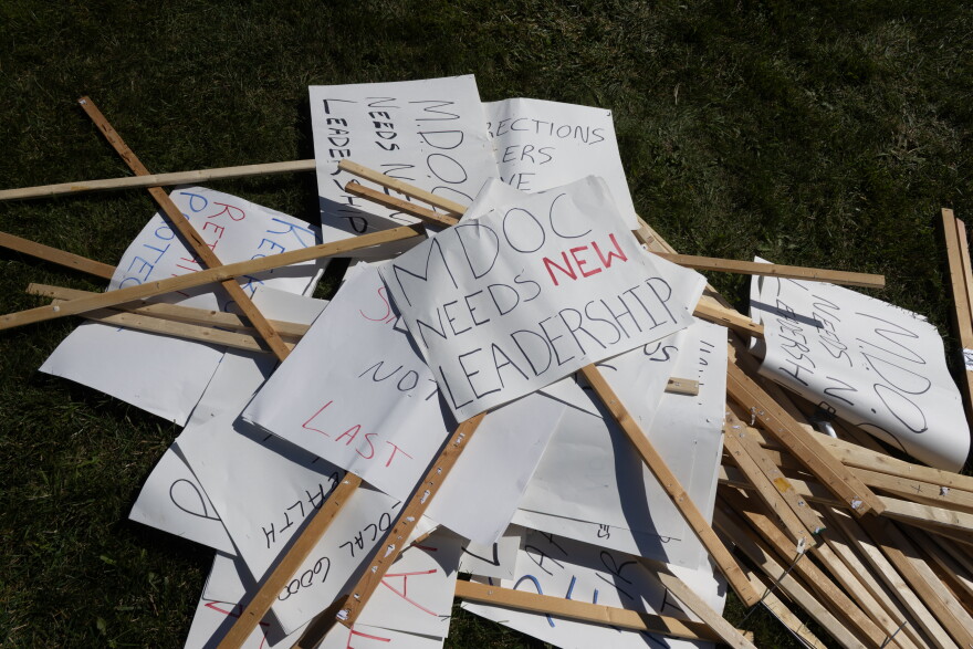 Signs pile up after being dropped by people picketing against Michigan’s Department of Corrections on Tuesday, Sept. 22, 2026.