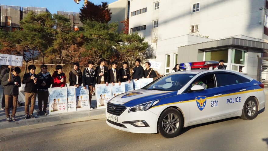 Younger students cheer on high school seniors as they head to the all-important college entrance exam on Thursday. As usual, police offered escorts for students who were running late.