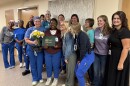 Shana Bennefield, center, holds her DAISY award with her nursing colleagues at Essentia Health in Fargo.