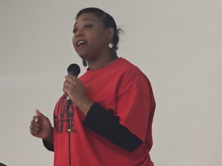 Woman with mic in red Black Lives Matter shirt