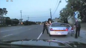 In this image made from July 6, 2016, video captured by a camera in the squad car of St. Anthony Police officer Jeronimo Yanez, the Minnesota police officer is shown after shooting into the vehicle at Philando Castile during a traffic stop in Falcon Heights, Minn., as the 4-year-old daughter of Castile's girlfriend, Diamond Reynolds, starts to get out of the car and is grabbed by an officer. (St. Anthony Police Department via AP)