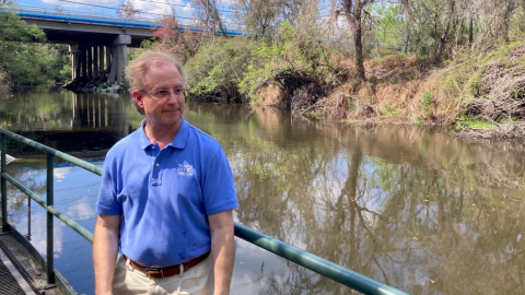 Hombre de pie junto a un río