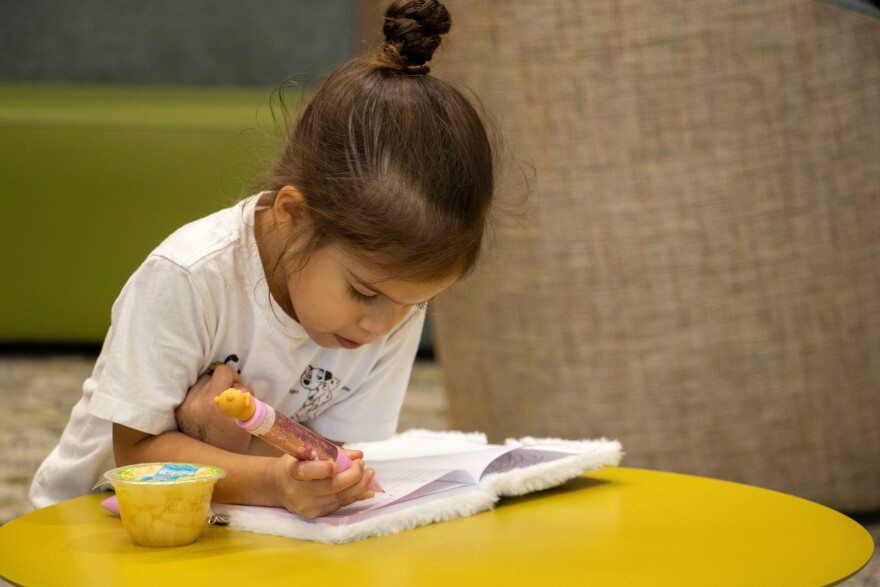 Four-year-old Emi Lopez writes in her Hello Kitty notebook at the South Education Center.