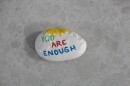 As domestic violence surges across Colorado, a painted rock at PorchLight Family Justice Center in Lakewood offers a reminder to survivors: “You Are Enough.”