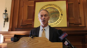 New Bedford Mayor Jon Mitchell gives a speech at a podium.